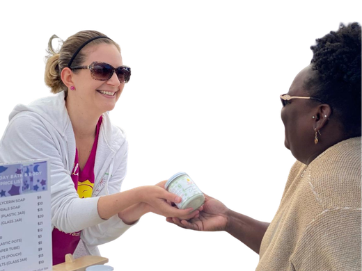 Volunteer speaking with a vendor at a local market table